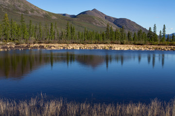 Reflection of mountains in calm water of the lake. Lake Labynkyr. Yakutia. Russia.