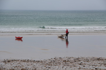 kayakiste préparant son kayak sur la plage