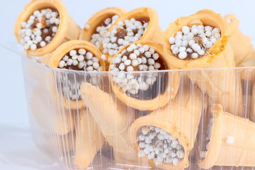 Вафли с кремом для десерта в пластиковой коробке.