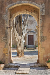 Fototapeta na wymiar The old tree in the Arkadi Monastery, Crete, Greece (view through arch)