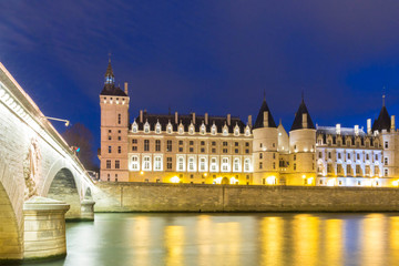 the Conciergerie castle at night, Paris, France.