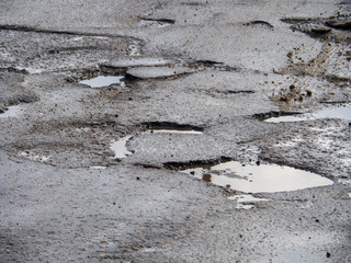 Hole in the asphalt, bad road, the risk of movement by car. Damage. Winter, Russia, 2017