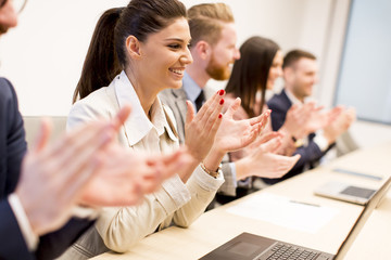Young business people clapping their hands in office