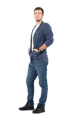 Smiling relaxed man in jeans and denim shirt with hands in pockets. Full body length portrait isolated over white background.