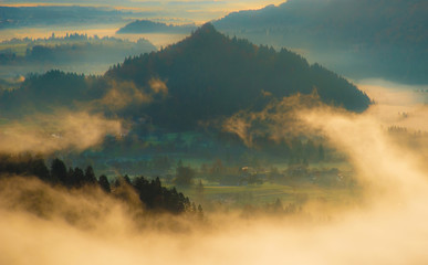mystical landscape with fog in the valley in the mountains