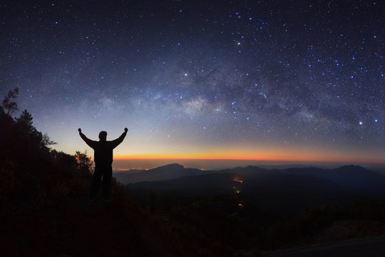 milky way galaxy and silhouette of a standing happy man on Doi inthanon Chiang mai, Thailand.