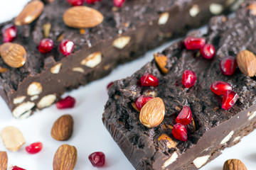 Homemade nut fudge with almond and pomegranate seeds on white background