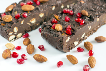 Homemade nut fudge with almond and pomegranate seeds on white background