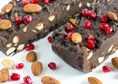 Homemade nut fudge with almond and pomegranate seeds on white background