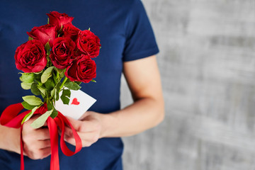 a man with red roses and valentine in the hands