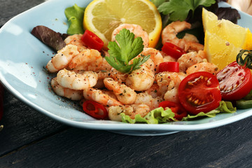 fresh shrimps served on a plate with garlic onion, lemon and chili