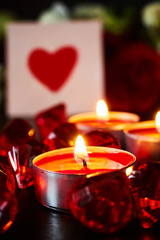 Valentine's day concept. red candles and a card with a heart