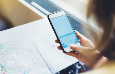 Enjoying travel. Young woman traveling by train sitting near the window using smartphone and looking map. Tourist texting online message and plan route of railway, railroad transport concept mock up