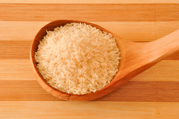 Fototapeta na wymiar Raw short rice on the wooden spoon