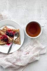 Pancakes with sweet fruit jam and tea. Food photo. Top view