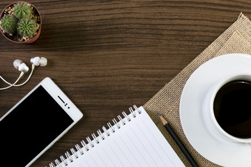 Cup of coffee and smartphone on wooden background