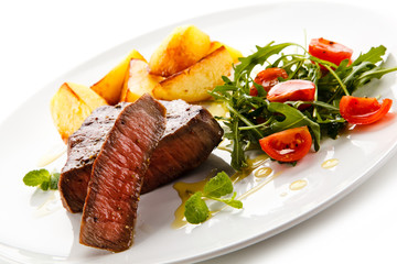 Grilled steaks, baked potatoes and vegetables 