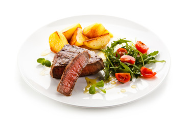 Grilled steaks, baked potatoes and vegetables 