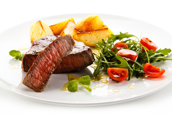 Grilled steaks, baked potatoes and vegetables 