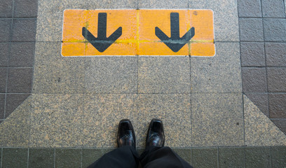 Arrow sign with shoes on Railway platform at train station.