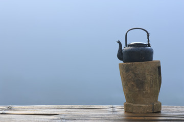 old and black retro kettle for coffee or tea place on wood platform and table or floor in the...