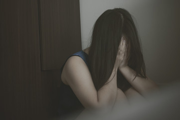 Woman covering her face in fear of domestic violence