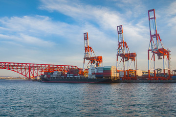 Fototapeta premium Transportation and Logistics of International with ports container cargo ship crane bridge in harbor for logistic import export background and transport industry concept