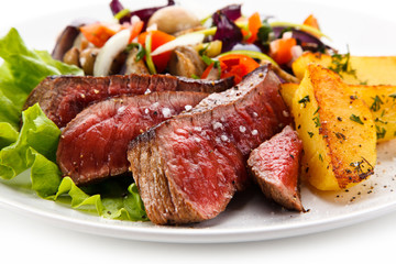 Steaks, baked potatoes and vegetable salad