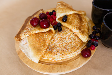 delicious pancakes on wooden table with orange and orange juice