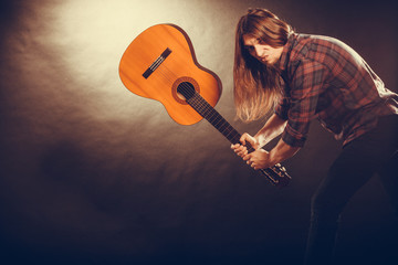 Rock musician destroys his guitar.