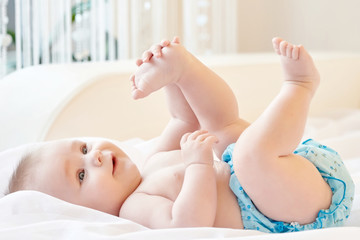 Fototapeta na wymiar small baby playing with his leg