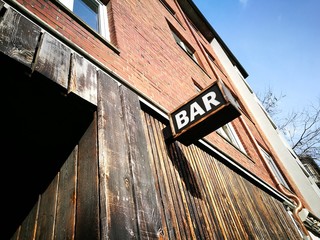 Kleine Bar mit verwitterter Fassade mit alten Schiffsdielen bei blauem Himmel und Sonnenschein am...