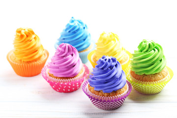 Tasty cupcakes on a white wooden table