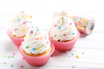 Tasty cupcakes on a white wooden table