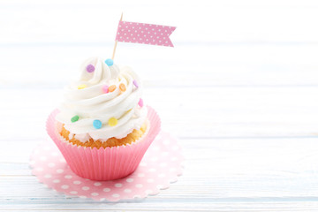 Tasty cupcake on a white wooden table