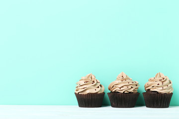 Tasty cupcakes on a green background