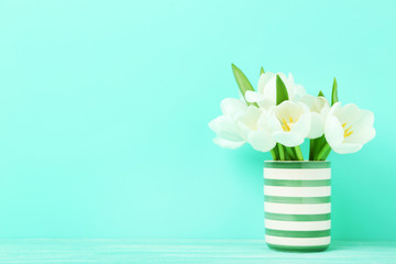 Bouquet of tulips in vase on green background