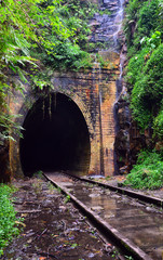 Waterfall cascading across the entrance to an historic abandoned railway tunnel in Helensburg, New South Wales, Australia