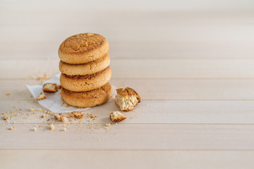 A stack of fresh delicious cookies on a wooden background. Crumbs on the table. Sweet Home, a cozy family home morning.