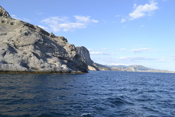 Naklejka premium sea,beach,Crimea,Sudak,fortress,castle,Genoese fortress,Ukraine,mountains,cliffs,rocks, sea,sky,blue sky,sun,sea, stones,waves,spray,water,cat,gray cat,cat,smoothie,drink,glass,cherry,cocktail,Seagull