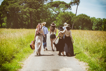 Groupe de jeunes Hipster de dos, marchant sur la route de campagne