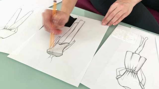 Female fashion designer sketching new dresses and models