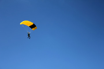 skydiver on clear blue sky, parachutist