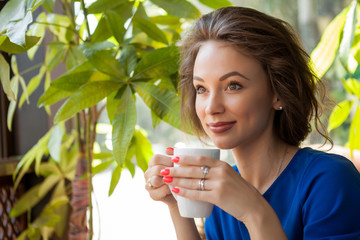 Beautiful young woman drinking coffe in a coffee shop