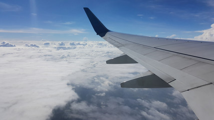 Obraz premium Wing airplane over the blue sky and cloudy while flying