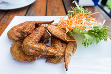 Chichen wing fried with salad in white dish on wooden table with copyspace ,flat lay ,selective focus