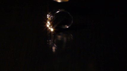 Various Pieces Of Jewelry Fall On Black Reflective Surface, Super Slow Motion. - Powered by Adobe