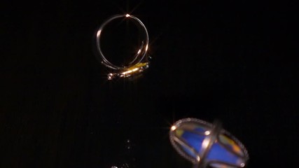 Various Pieces Of Jewelry Fall On Black Reflective Surface, Super Slow Motion. - Powered by Adobe