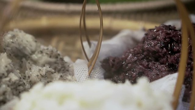 Steaming 3 colors stick rice, white, purple and sesame mixed in Thai market