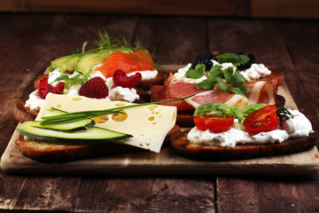 Bread Brushetta or authentic traditional spanish tapas set for lunch table. Sharing antipasti on party or summer picnic time over wooden rustic background.